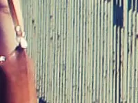 A woman walks down the road with a suitcase