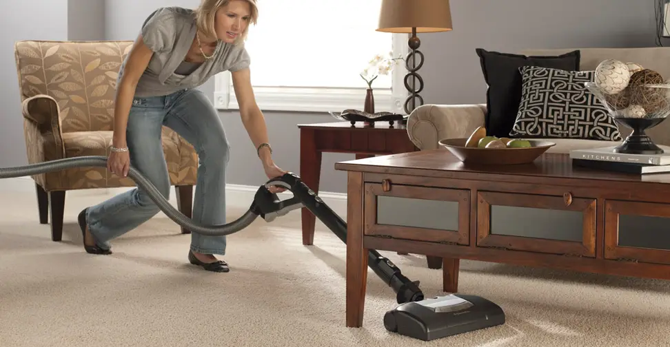 A woman vacuuming a living room