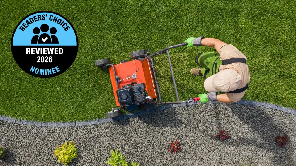 A service person mows a lawn