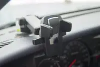 A phone holder mounted to the dashboard of a car