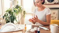 A photo of a woman giving herself a manicure.