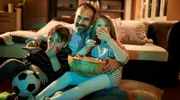 Dad and two kids watching a movie at home