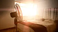A fan in a sunlit bedroom