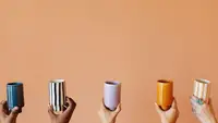 Five hands hold up different colored ceramic cups