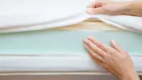 hands show the layers of a mattress