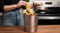Woman putting banana peel into stainless steel countertop compost bin.