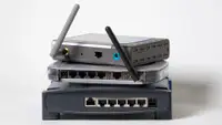 A number of wireless routers, stacked on top of one another.