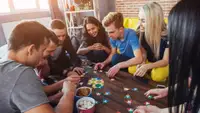 Adults sitting around table playing board game