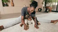 Woman smiling and stretching on floor with baby.