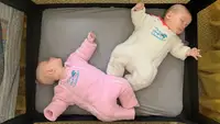 Two babies wearing Baby Merlin’s Magic Sleepsuit lay down for a nap.