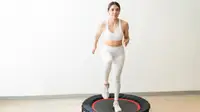 A woman jumping on a rebounder.