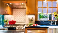 Modern kitchen with wooden cabinets and white tile backsplash.