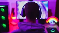 A person wearing headphones and sitting in front of a computer monitor