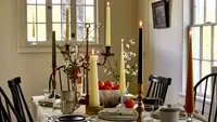 A variety of tall candles on a dining room table