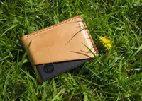 A wallet laying on green grass