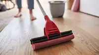 Woman cleaning a floor with a mop and bucket