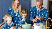 A family wearing matching Hanukkah pajamas making potato pancakes in a kitchen