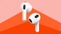 Close up of the newest Apple AirPods against a red background.