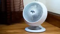 A white Vornado fan sitting on the floor.