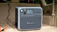 A solar powered generator sits in a car trunk.