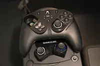 The Thrustmaster eSwap S Pro controller sitting atop a Nintendo Gamecube with spare thumbsticks on display..