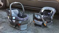 Two car seats sitting on the ground next to a car.