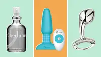 A collection of sex toys and some lube in front of a background.