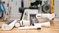 Tineco S15 Pet with its brush head, mini power brush, crevice and dusting tool on a workbench