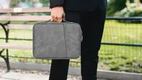 A man carrying his tablet in his tablet case to work.