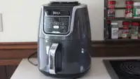 The Ninja Air Fryer XL standing on display atop a table.