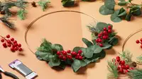 A hoop wreath sitting at the center surrounded by fake flowers and floral wire.