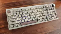 The Epomaker RT100 Mechanical Keyboard with the RGB keys on laying flat on a table.