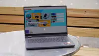 The Lenovo Legion Slim 5 14APH8 open, on a table, with a purple and blue design on the screen.