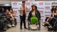 Two disabled people on runway showcasing clothes.