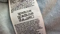 A clothing tag on a vest with wash instructions.