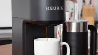Close-up of a Keurig coffee machine brewing coffee into a white mug