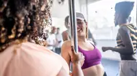 A group of students enjoying a pole dance class
