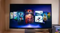 A 3D gaming monitor sits on a desk with video games gallery on its screen