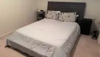 Gray Cozy Bliss comforter on a full-sized bed in a bedroom with beige walls and a brown headboard.