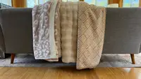 Three throw blankets placed on a couch