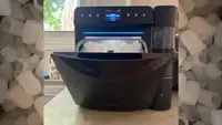 Black Govee Smart Countertop Ice Maker 2 on a kitchen counter, open and showing ice inside.