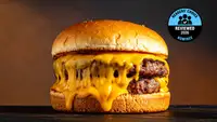 A large double patty burger drips with orange cheese