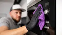 Man cleaning an oven
