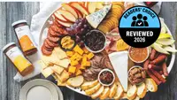 A deli platter with an assortment of cheese and fruit, with a 