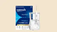the waterpik Aquarius water flosser in white in front of a beige background with the blue package