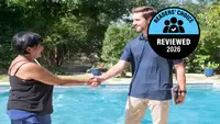 A man and woman shaking hands in front of an outdoor pool