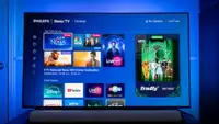 Philips Ambilight 7985 TV displaying Roku streaming options with blue illuminated light behind it.