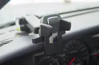 A phone holder mounted to the dashboard of a car