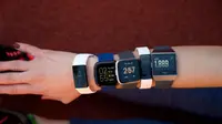 Five different Fitbits worn on a woman's arm
