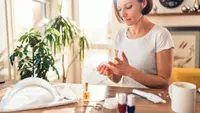 A photo of a woman giving herself a manicure.